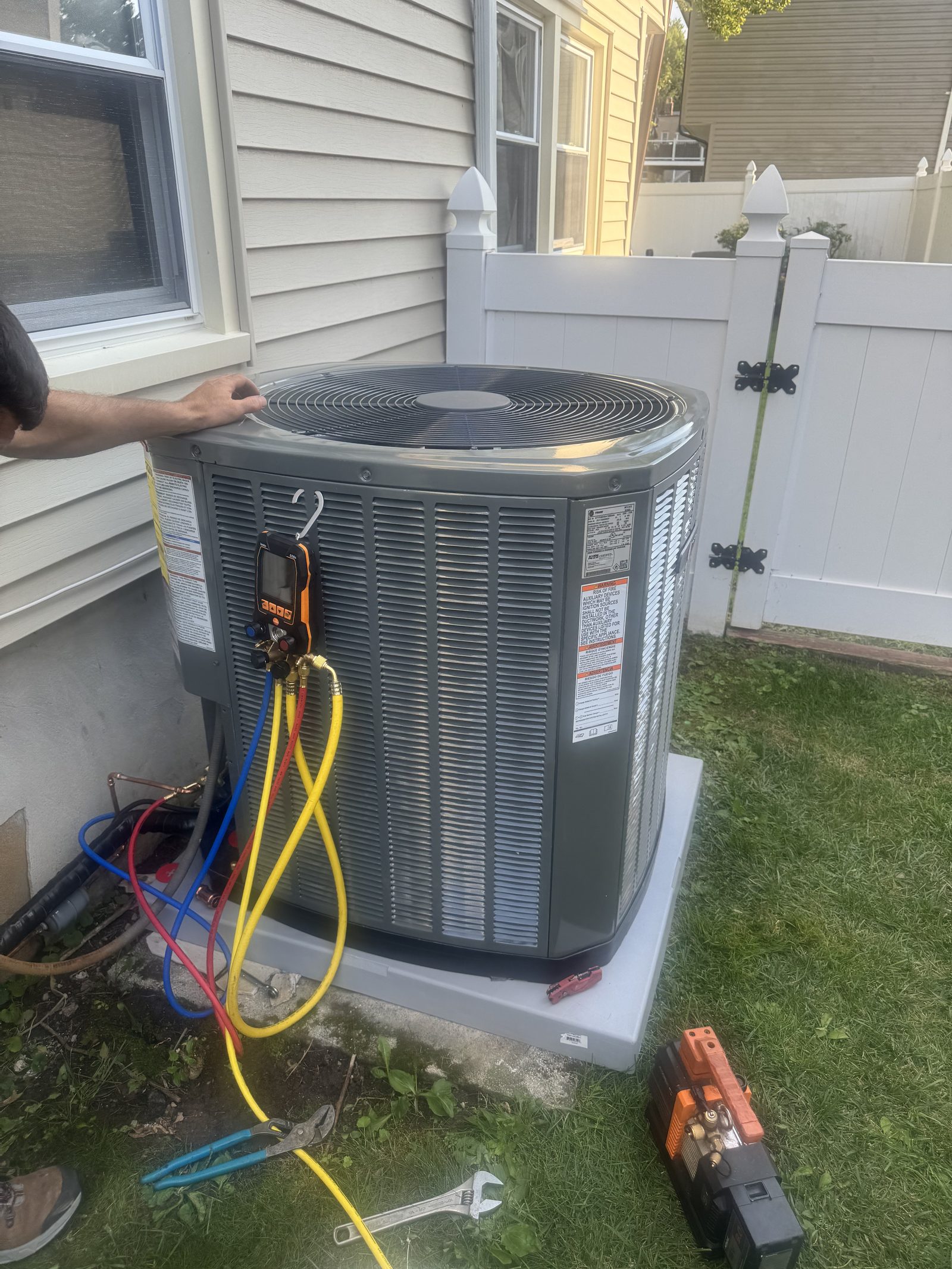 Refrigerant gauges connected to an AC condenser during a service call in New Jersey