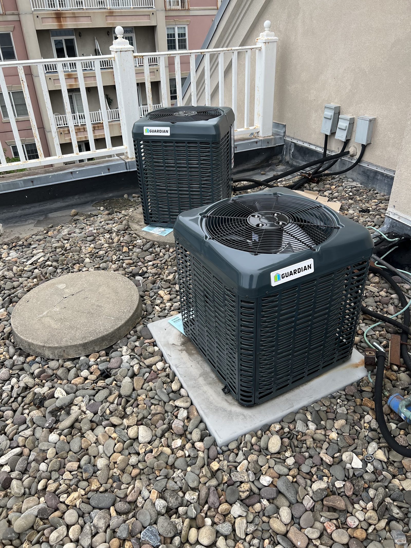 New central air conditioner condenser installed on a rooftop in Bergen County, NJ