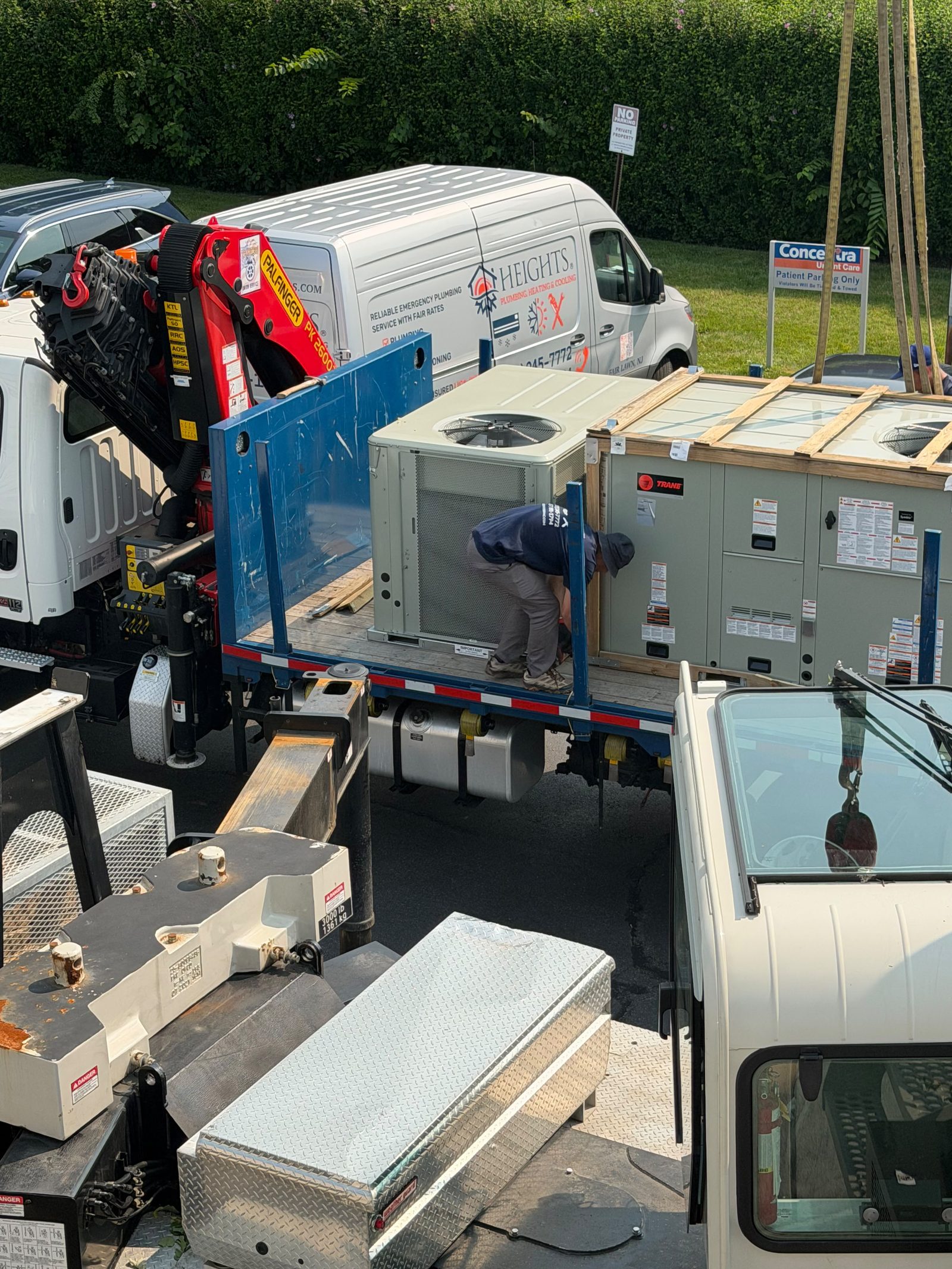 Heights crew rigging a rooftop HVAC unit on a crane truck in New Jersey