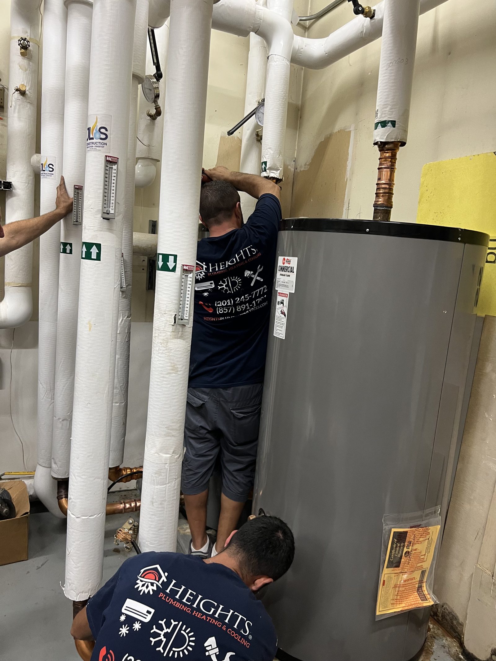 Heights technicians installing commercial water heaters in a New Jersey boiler room